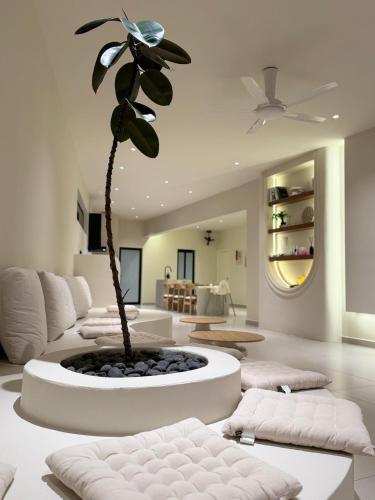 a living room with a palm tree in the middle of the room at Taiping Corner Homestay in Taiping