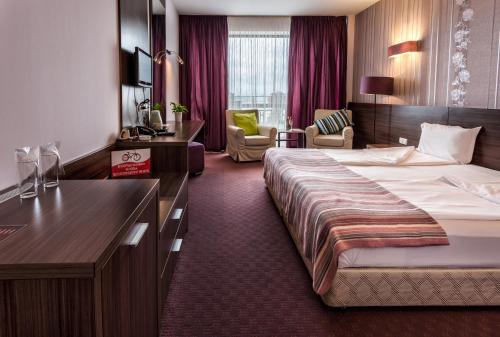 a hotel room with a large bed and a desk at Family Hotel - Restaurant Ring in Montana