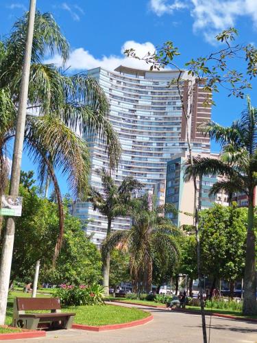 un edificio alto con palmeras en un parque en Oceanview Frente Mar 130m2, en Santos