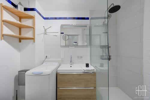 Un baño blanco con lavabo y ducha en Appartement hyper centre - Parking - 2v, en Tours
