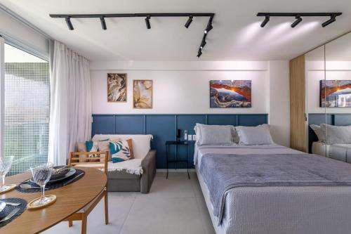 Un dormitorio con dos camas y un sofá y una mesa. en RN Studio Apê 506, en Maceió