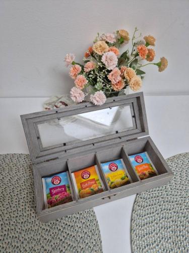 a wooden box with a vase of flowers and cookies at City Nest Apartments NS in Novi Sad