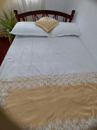 een bed met een wit dekbed en kussens bij Golden Breeze Villa Bentota in Beruwala
