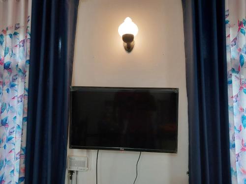 a television with a light attached to a wall at Golden Breeze Villa in Beruwala