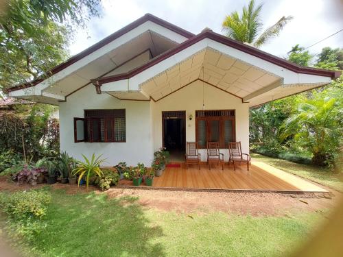 a small white house with a porch and chairs at Golden Breeze Villa in Beruwala