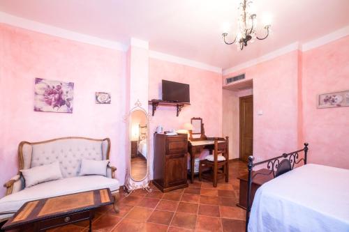 a bedroom with pink walls and a bed and a desk at Hotel Relais Pian delle Starze in Marina di Camerota