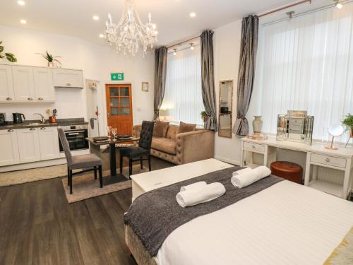 a bedroom with a bed and a living room at The Railway Apartment in Hexham