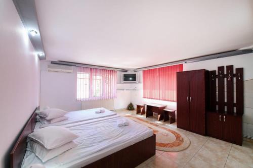 Un dormitorio con una cama grande y un comedor. en Casa Delia Vatra Dornei, en Vatra Dornei