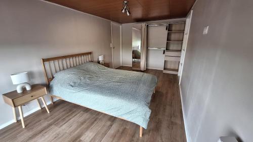 a small bedroom with a bed and a wooden floor at Appartement spacieux tout équipé au coeur de l'avesnois in Trélon