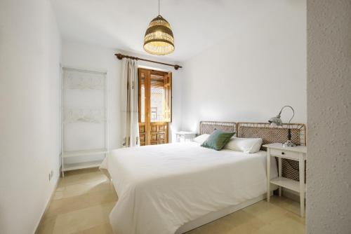 ein weißes Schlafzimmer mit einem weißen Bett und einem Fenster in der Unterkunft Oliva y Limón - Acogedor Apartamento en Pedraza in Pedraza