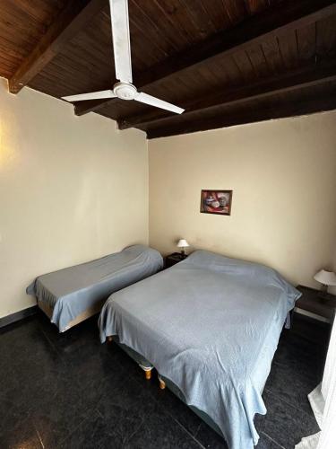 two beds in a bedroom with a ceiling fan at Olmueh Ranch in Olmué