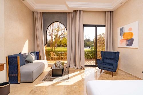 un salon avec un canapé et une chaise dans l'établissement Palais Nouhass, à Marrakech