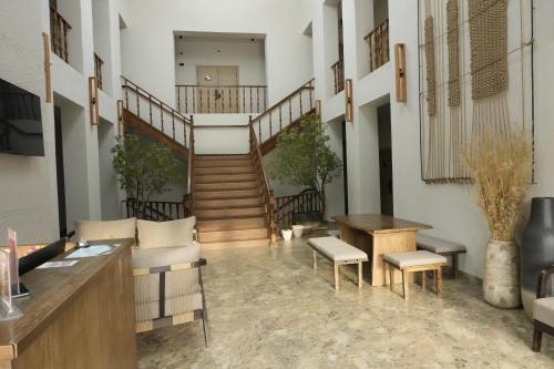 Un vestíbulo con una escalera y una mesa y sillas. en Hills Hotel, en Karakol