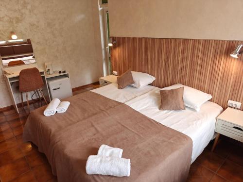 a hotel room with two beds with towels on them at Noviz Hotel in Plovdiv