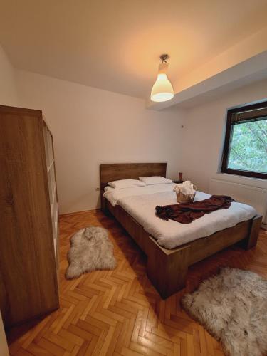 a bedroom with a bed and two rugs on the floor at Quiet, Family-Friendly House with Garden & Parking in Skopje