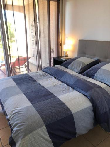 a bedroom with two beds and a view of a balcony at Résidence L'écume in Saint-Cyprien-Plage