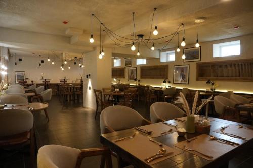 Un restaurante con mesas y sillas en una sala. en Hills Hotel, en Karakol