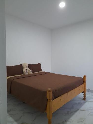 a bed with a teddy bear sitting on top of it at Sal Blue Apartment in Santa Maria