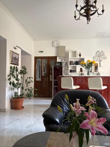 a living room with a black leather couch and a kitchen at Velez Ház in Budapest
