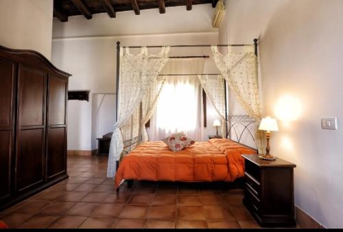 - une chambre avec un lit doté d'un couvre-lit orange et d'une fenêtre dans l'établissement Agriturismo sanacore di sanacore salvatore, à Rilievo
