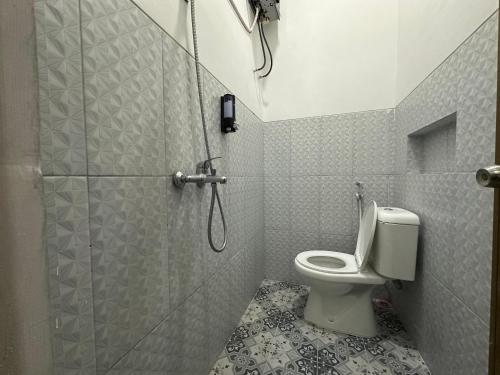 a bathroom with a shower and a toilet at TWD hostel in Gadang