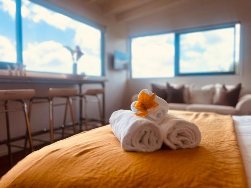une pile de serviettes posée sur un lit dans l'établissement Floriana on Church - Oneroa, à Waiheke Island