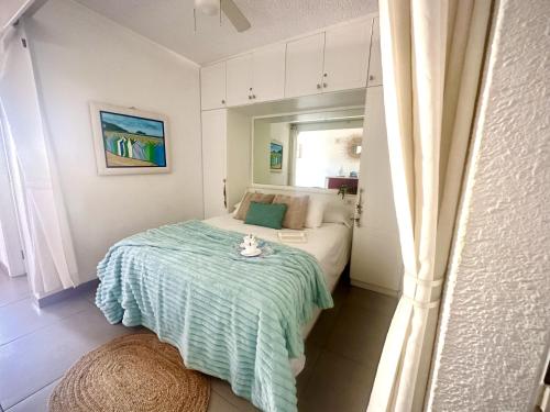 a small bedroom with a bed and a table at Royal Garden Sea Views by Deihu Experiences in Playa de las Americas