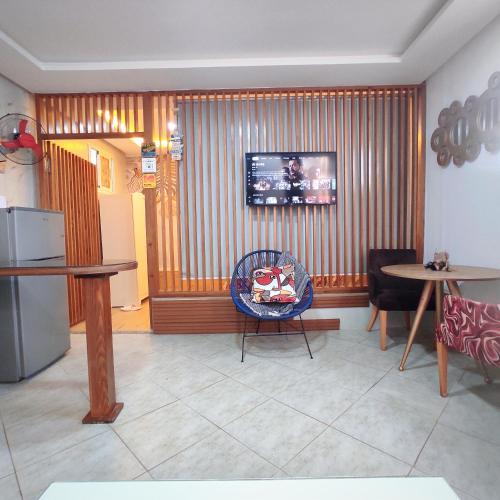 joli studio avec terasse au coeur harhoura في تمارة: غرفة معيشة مع طاولات وتلفزيون على الحائط