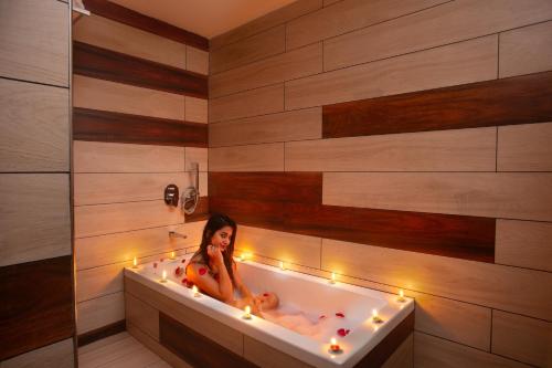 a woman sitting in a bath tub with candles at The Grand Sanvika in Ramakkalmedu