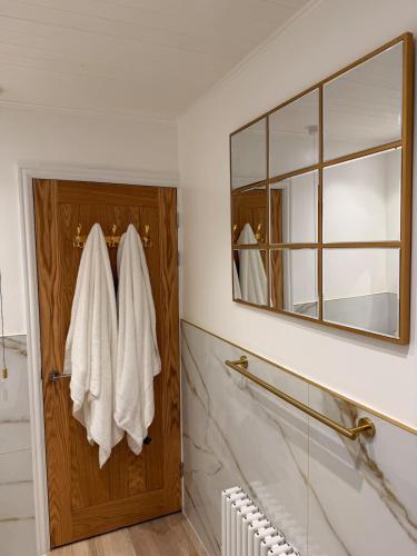 a bathroom with a wooden door and a mirror at The Stanhope - Ground Floor Apartment in Frecheville