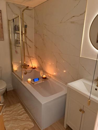 a bathroom with a tub and a shower with candles at The Stanhope - Ground Floor Apartment in Frecheville