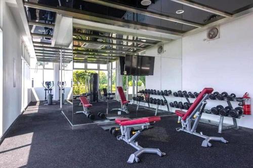 einen Fitnessraum mit Laufbändern und einem Flachbild-TV in der Unterkunft Sutera Avenue by AEM RESIDENCES in Kota Kinabalu