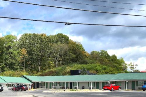 a green building with cars parked in a parking lot at Holiday Motel by Belvilla Cleveland, TN in Cleveland