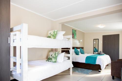 2 witte stapelbedden in een kamer bij Pinto City Motel East London in East London