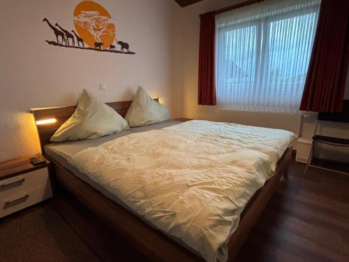 ein Schlafzimmer mit einem großen Bett mit weißer Bettwäsche in der Unterkunft Haus am See in Biersdorf