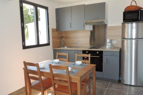 a kitchen with a table and chairs and a refrigerator at L'Ortu Di Pisettu -2 in Conca
