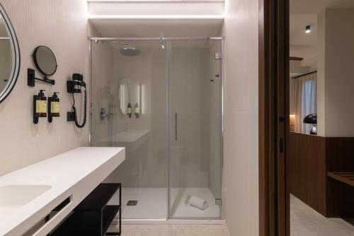 una ducha con puerta de cristal en un baño en Moontels Colón, en Valencia