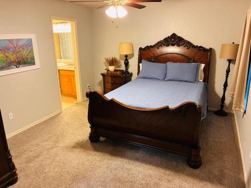 a bedroom with a large wooden bed with blue pillows at Paradise on the Prairie in Oklahoma City