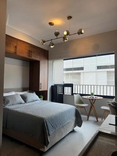 a bedroom with a bed and a table and chairs at Apartamento 300 m do metrô Tatuapé in São Paulo
