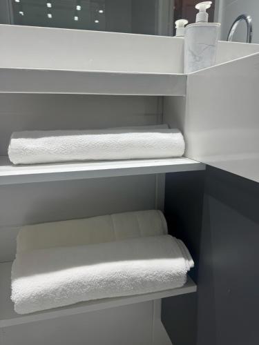 a bathroom with white towels on a shelf at Apartamento 300 m do metrô Tatuapé in São Paulo