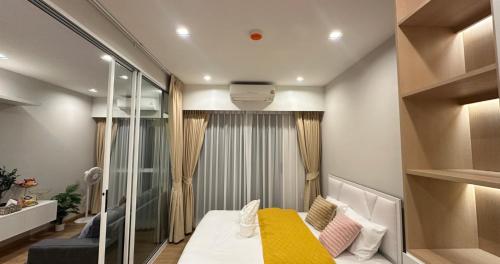 a small room with a bed and a mirror at The one ratchaphruek in Ban Nong Bua
