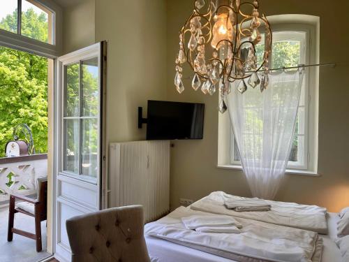 a bedroom with a bed and a chandelier at ciao-aschau Haus Burg Studio-Apartment101 in Aschau im Chiemgau