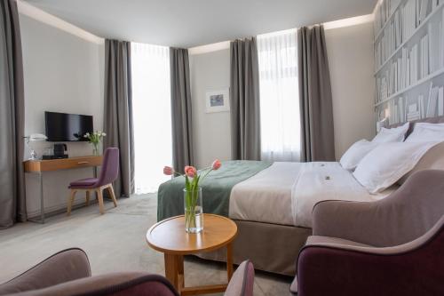 a hotel room with a bed and a table at Jump INN Hotel Belgrade in Belgrade