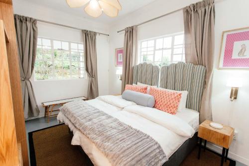 a bedroom with a large bed and two windows at 19 Mare St Apartments in Howick