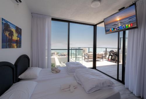 a bedroom with two beds and a large window at Levication Premium Private Jacuzzi Apartments in Tiberias