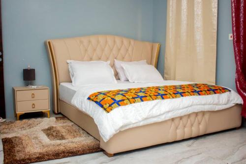 a bedroom with a large bed and a night stand at KapeView Elegant Suite in Cape Coast