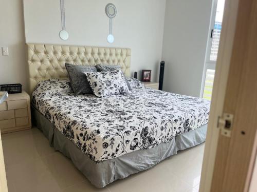 a bedroom with a bed with a black and white comforter at Apartamento salida al Mar Santa Marta in Santa Marta