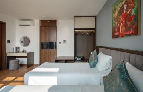 a bedroom with a large white bed and a kitchen at Luxe Paradise Hotel Nguyen Khac Hieu in Hanoi