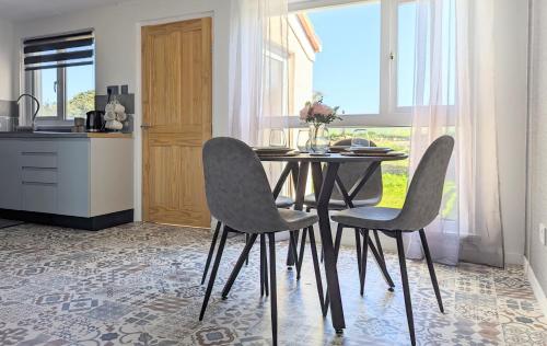 una cocina con una mesa y dos sillas en una cocina en Fairway house, en Kilchenzie