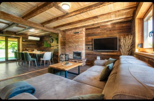 a living room with a large couch and a tv at Kuća za odmor Toma in Prvan Selo
